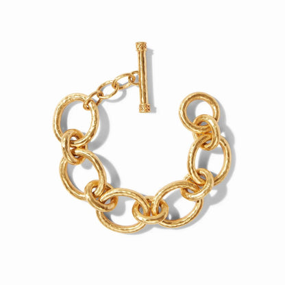 A chunky gold chain bracelet with a decorative toggle clasp, displayed on a white background.