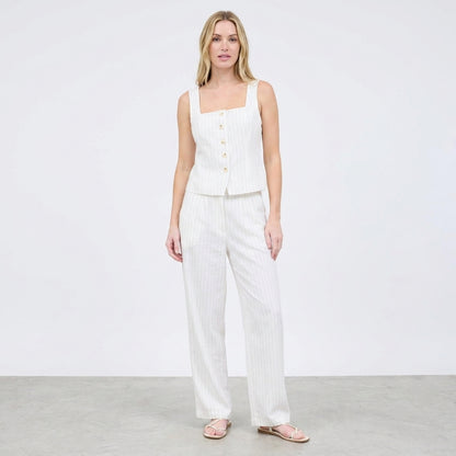 Woman in a white, buttoned top and pants ensemble.