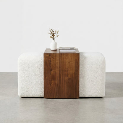 Rectangular wood panel on white textured cushions.