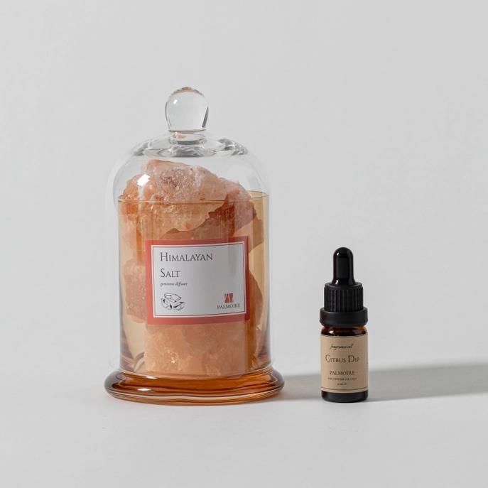 Himalayan salt crystals and citrus oil bottle on display.