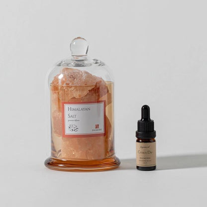 Himalayan salt crystals and citrus oil bottle on display.
