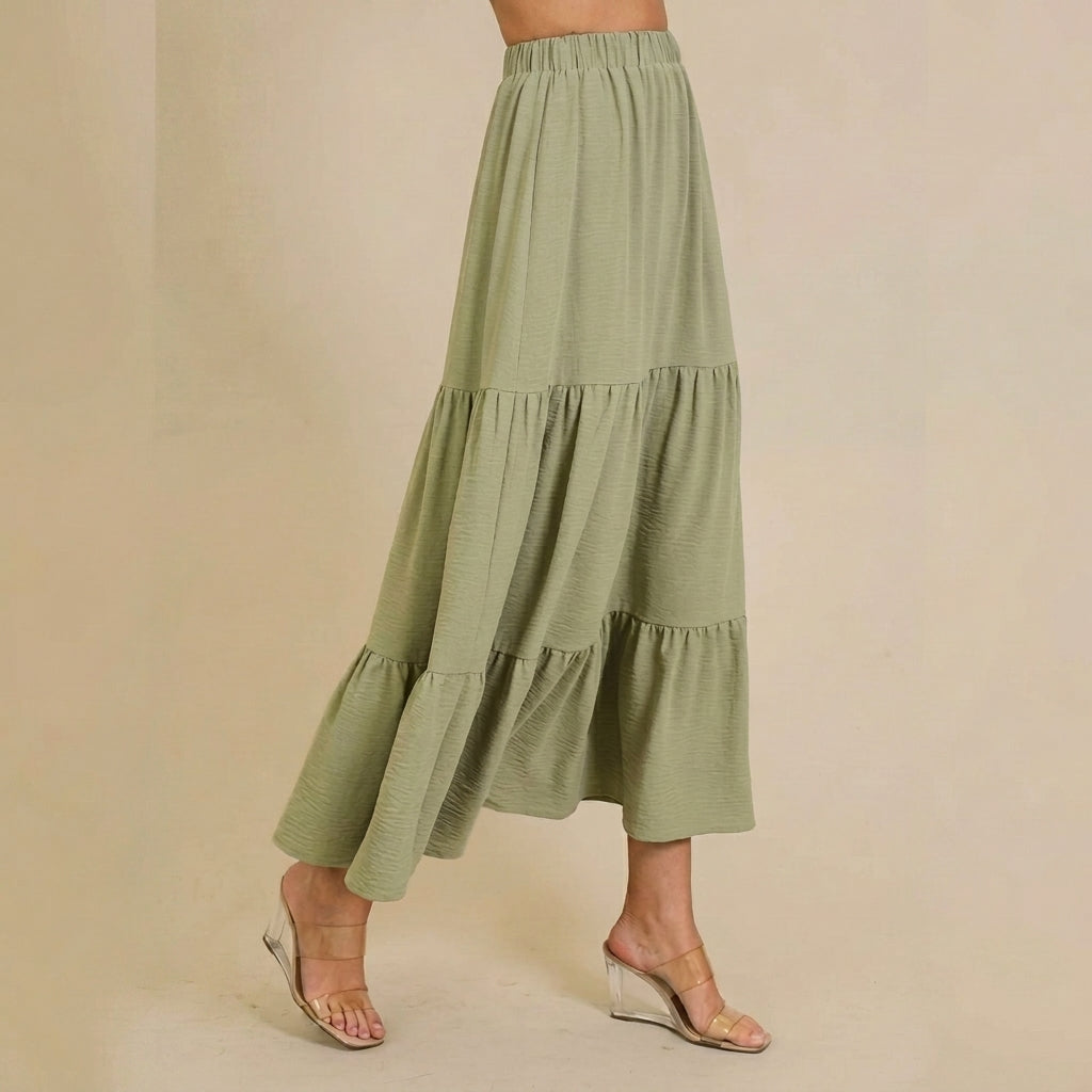 Green tiered maxi skirt with clear wedge sandals.