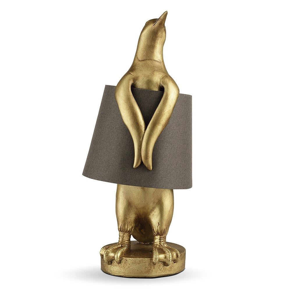 Gold penguin lamp with a grey lampshade.