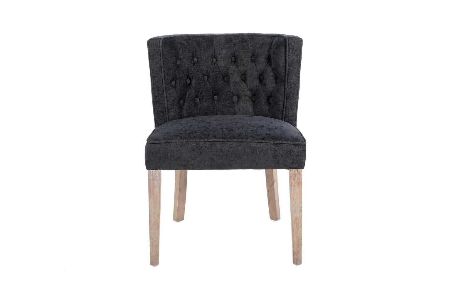 Dark grey tufted chair with light wooden legs.