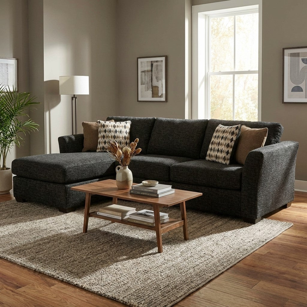 Cozy living room with a dark sectional sofa, wooden table, and soft lighting.