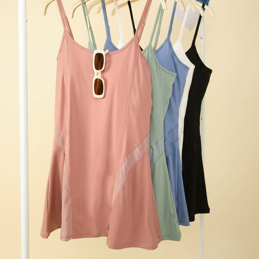 Four colorful dresses hanging on a rack with sunglasses.