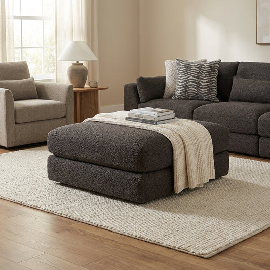 Dark sectional sofa with patterned pillows.