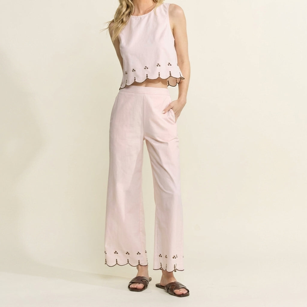 Woman in pink scalloped outfit with sandals.