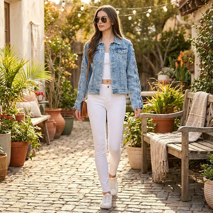 Woman in denim jacket holding a cup outdoors at a rustic café.