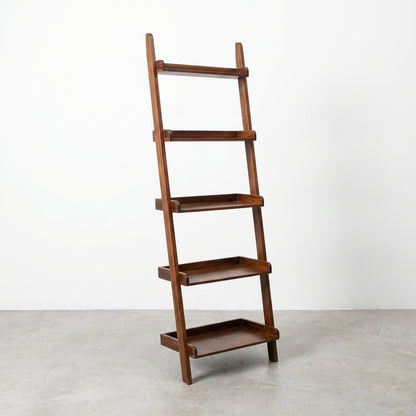Wooden ladder-style shelf with four tiers against a white wall.