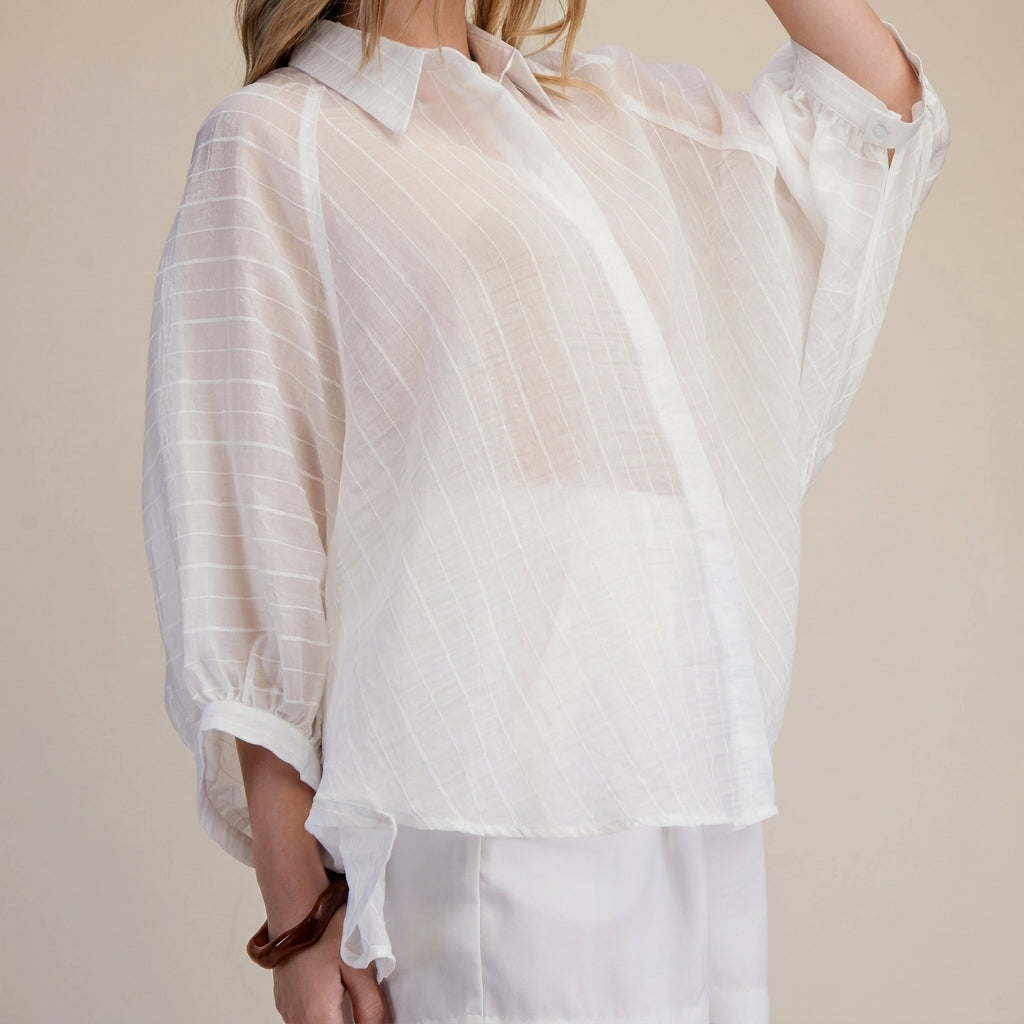 Sheer white blouse with subtle stripes.