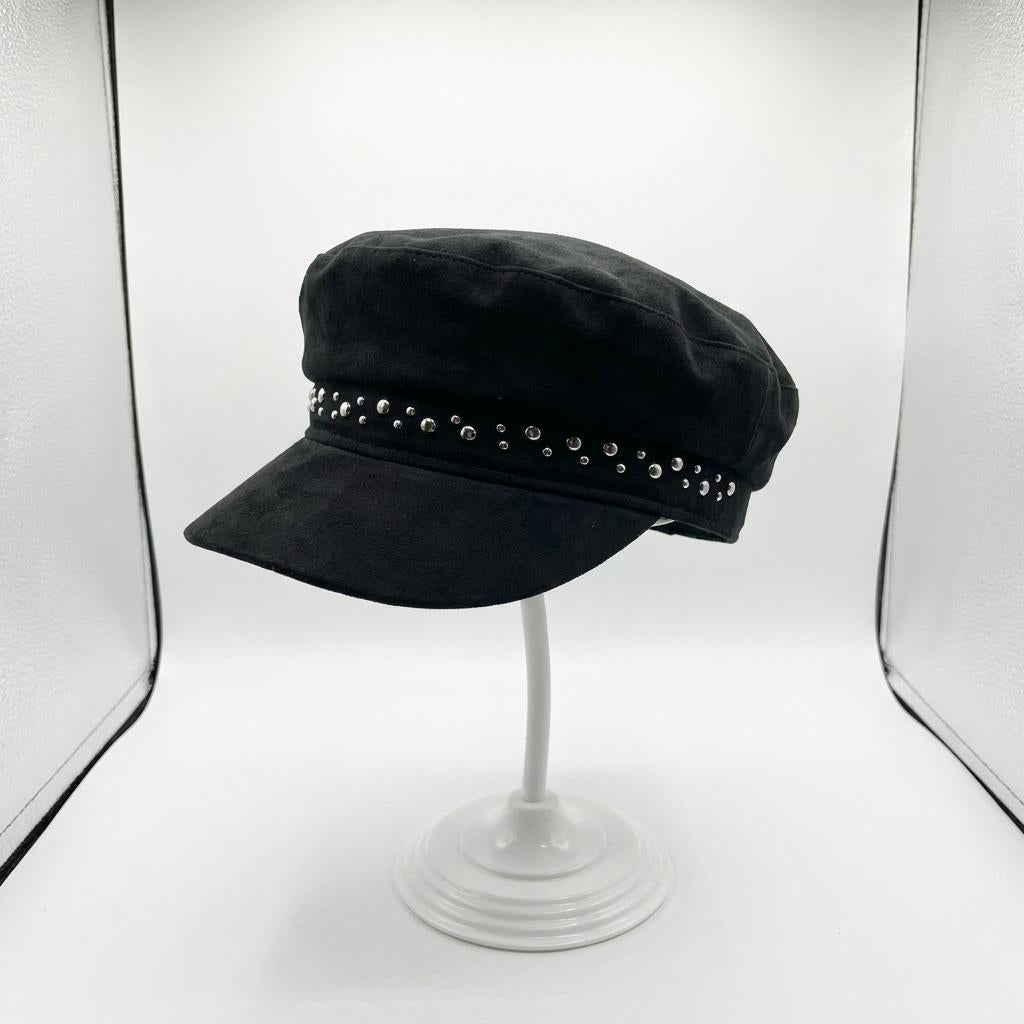 Black cap with studs on a stand in a lightbox setup.