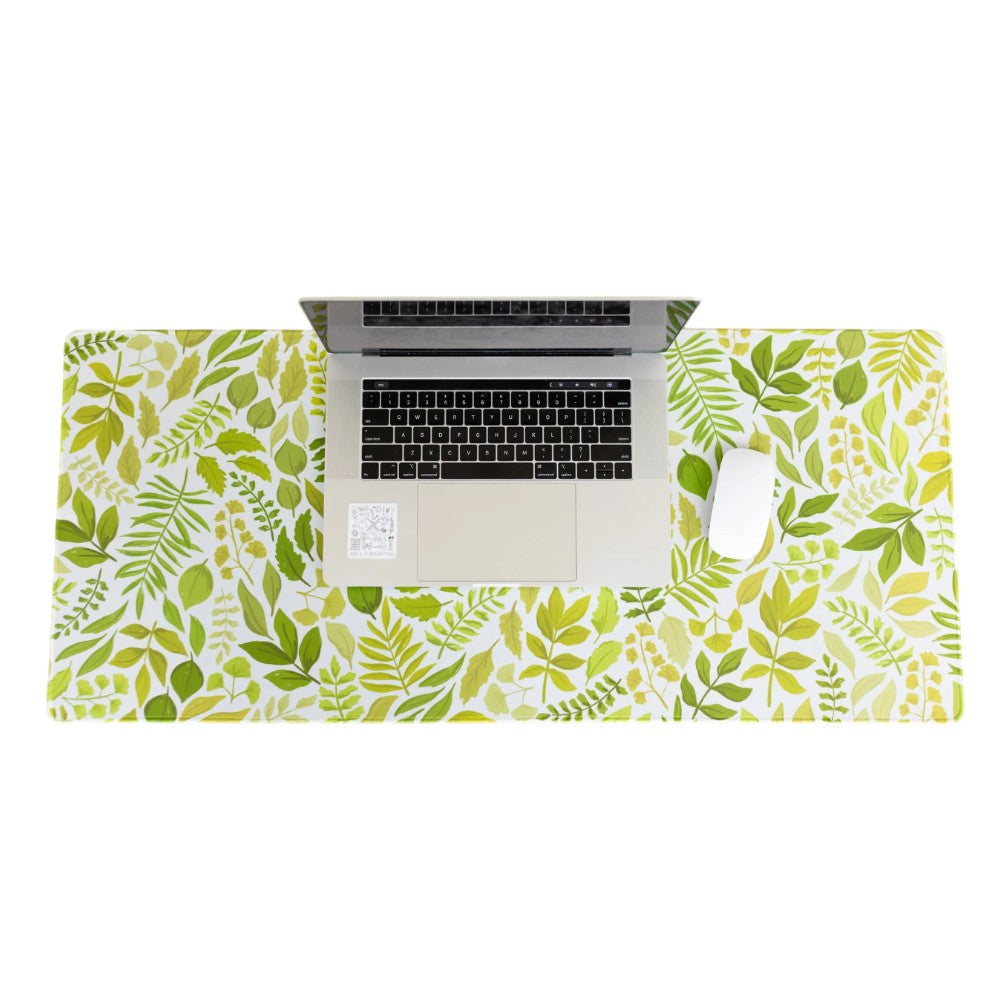 Laptop and mouse on a leafy-patterned desk mat.