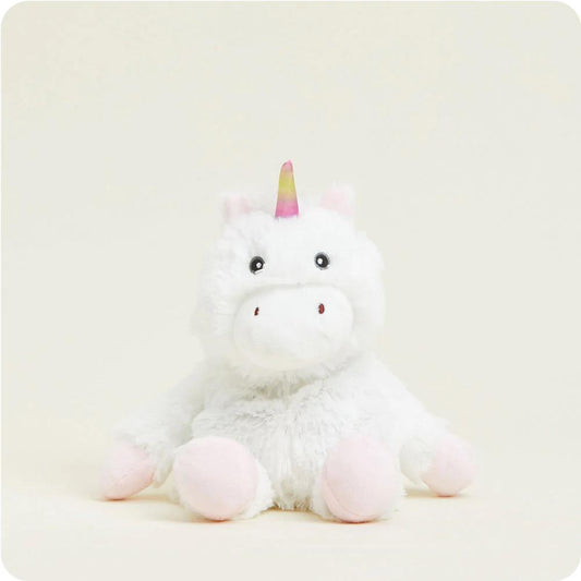 Plush white unicorn toy with rainbow horn sitting.