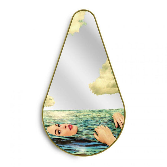 Teardrop mirror with woman swimming in ocean and sky reflection.