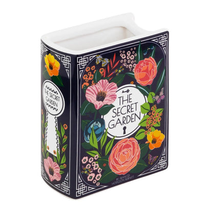 Vase shaped like "The Secret Garden" book, adorned with colorful floral designs.