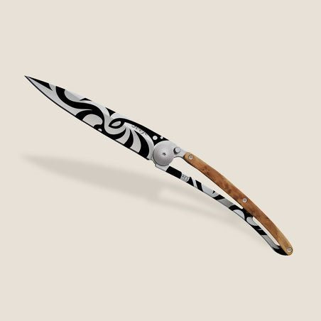 Stylish knife with a wooden handle and black and white swirled blade.