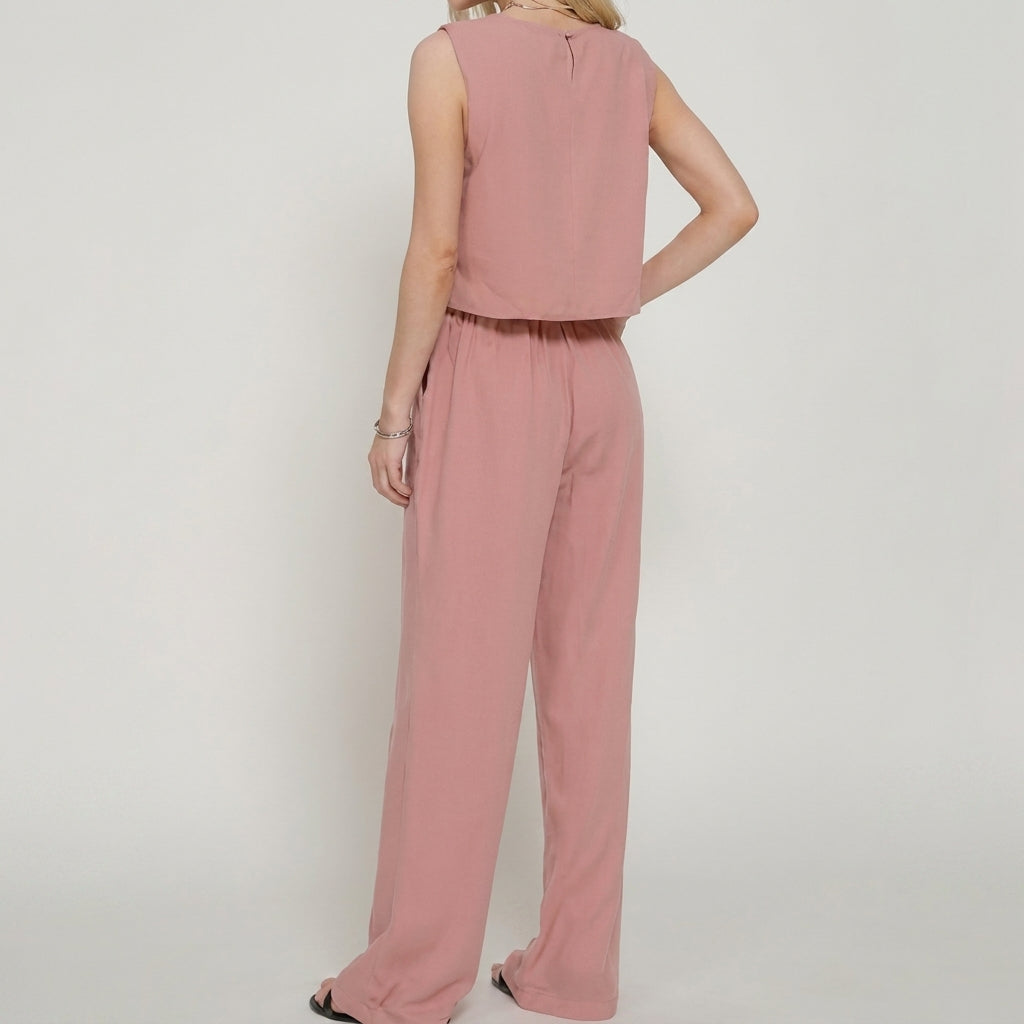 Woman in a pink sleeveless jumpsuit, viewed from the back.