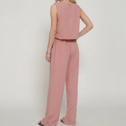 Woman in a pink sleeveless jumpsuit, viewed from the back.