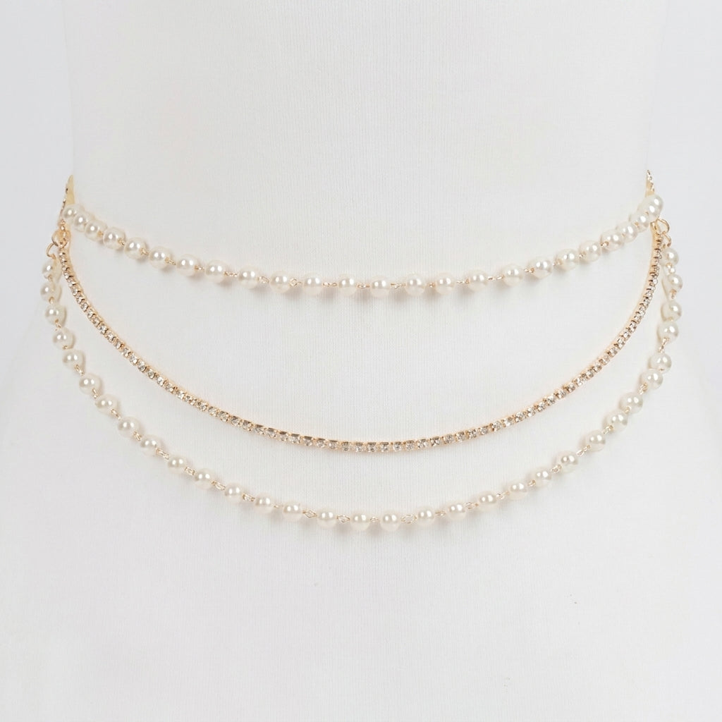 Elegant layered pearl and rhinestone waist chain on a white background.