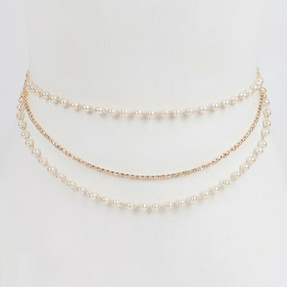 Elegant layered pearl and rhinestone waist chain on a white background.
