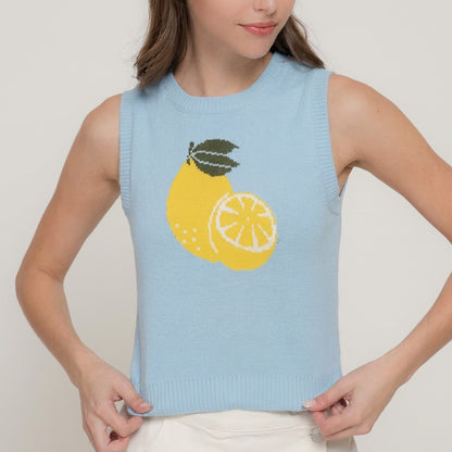 Woman in a blue lemon-graphic sleeveless sweater.