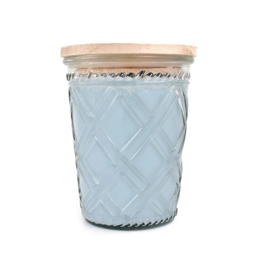 Blue candle in a textured glass jar with a wooden lid.