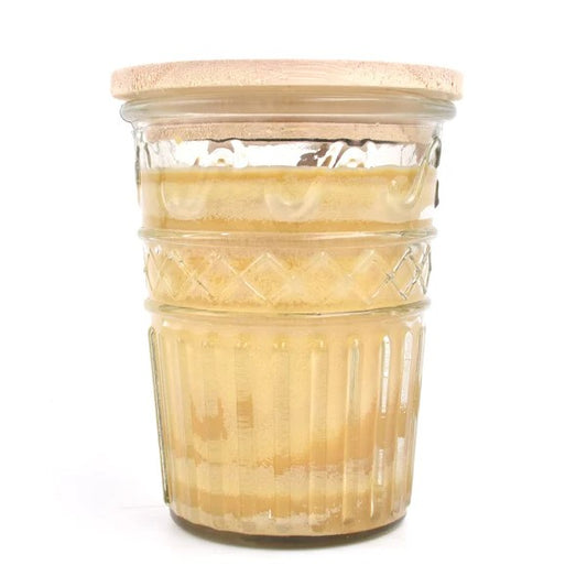 Glass jar with honey and a wooden lid.