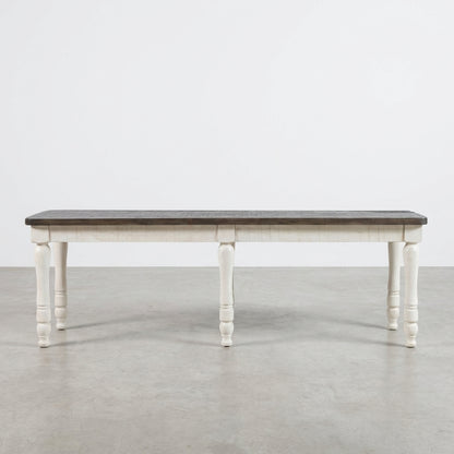 Wooden table with dark top and white turned legs.
