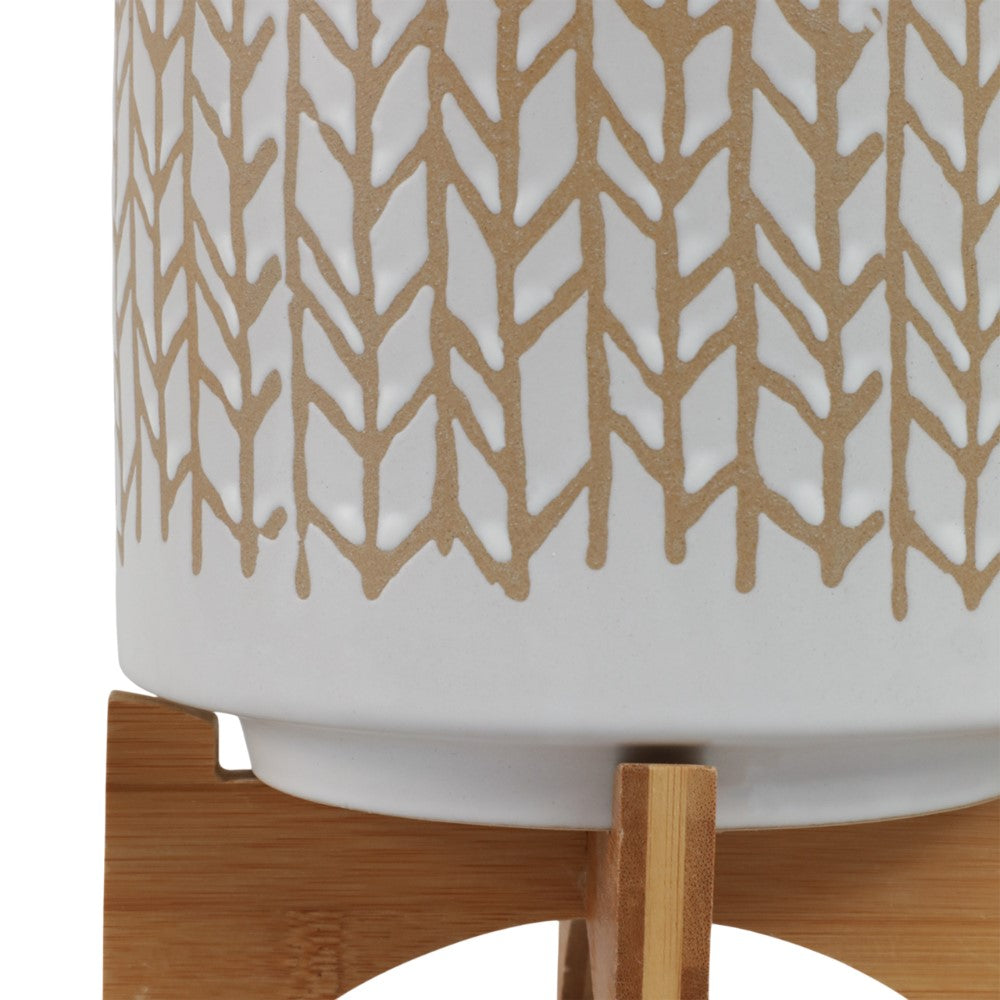 White ceramic pot with brown geometric pattern on a wooden stand.