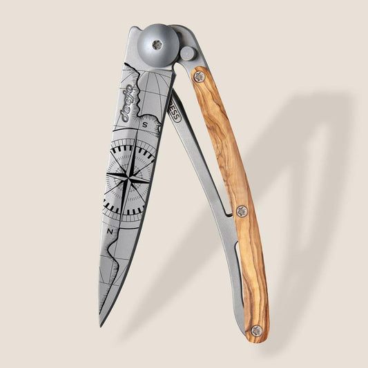Stylish folding knife with a compass design and wooden handle.