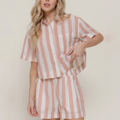 Woman in striped pink and white shirt and shorts.