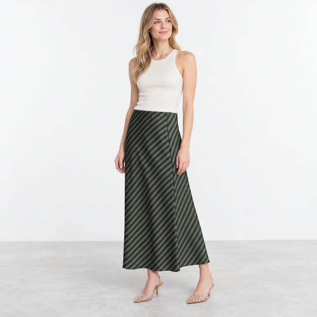 Model wearing a white tank top, striped maxi skirt, and embellished heels.