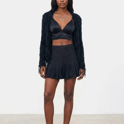 Woman in a black outfit with a cozy sweater.