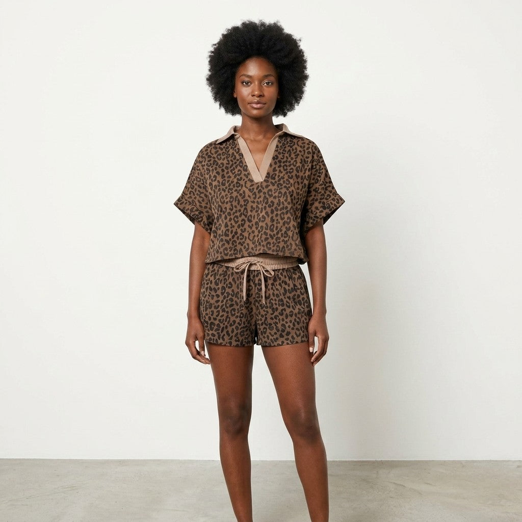 Woman in leopard print outfit, stands confidently against a plain background.