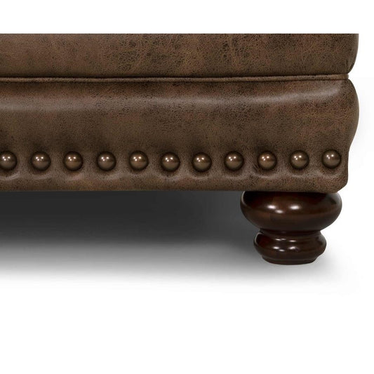 Brown leather furniture with studded trim and wooden leg.