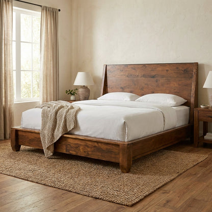 Cozy bedroom with a wooden bed, beige rug, and soft lighting.