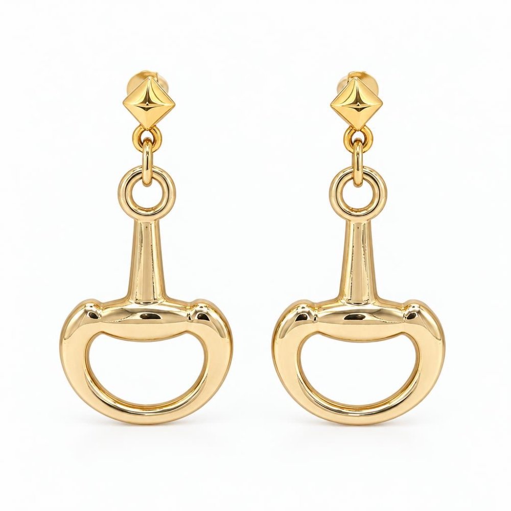 A pair of polished gold-tone drop earrings with geometric studs and oversized bit-shaped charms.