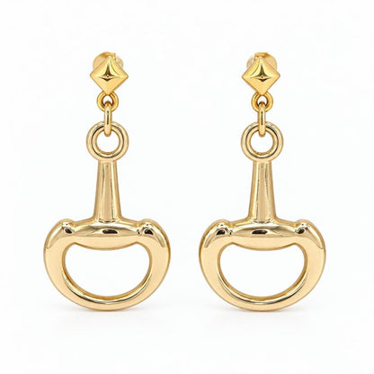 A pair of polished gold-tone drop earrings with geometric studs and oversized bit-shaped charms.