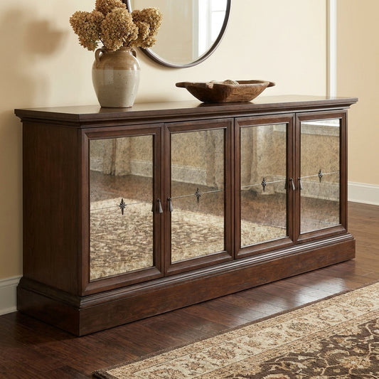 Wooden sideboard with mirrored doors, vase with flowers, and a decorative bowl on top.