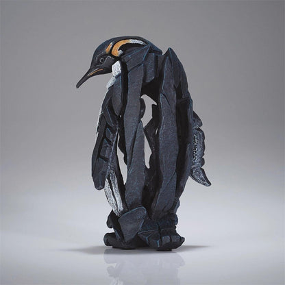 Abstract penguin sculpture made of angular, black stone pieces.