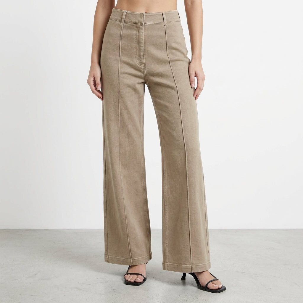 Woman wearing high-waisted beige wide-leg pants and black heels.