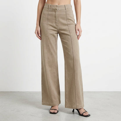 Woman wearing high-waisted beige wide-leg pants and black heels.