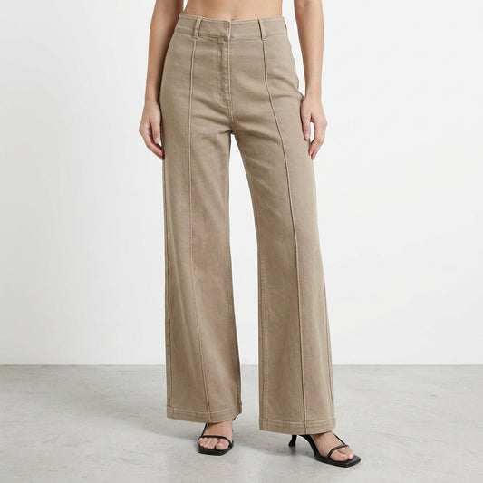 Woman wearing high-waisted beige wide-leg pants and black heels.