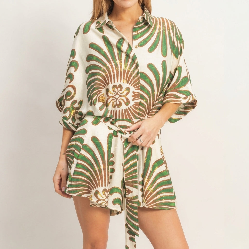 Woman wearing a green and brown patterned outfit, standing with hands on hips.