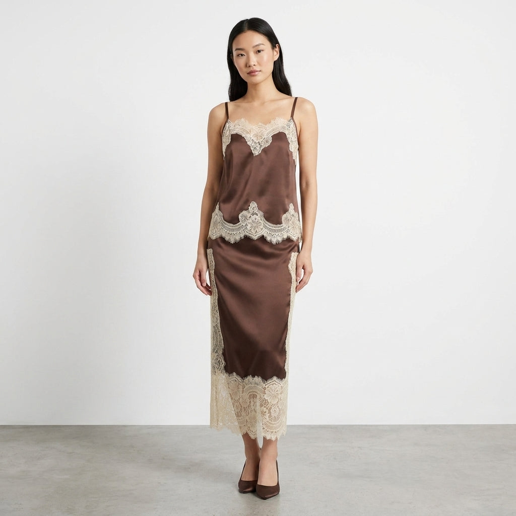 Woman in brown satin dress with lace accents stands on gray floor.