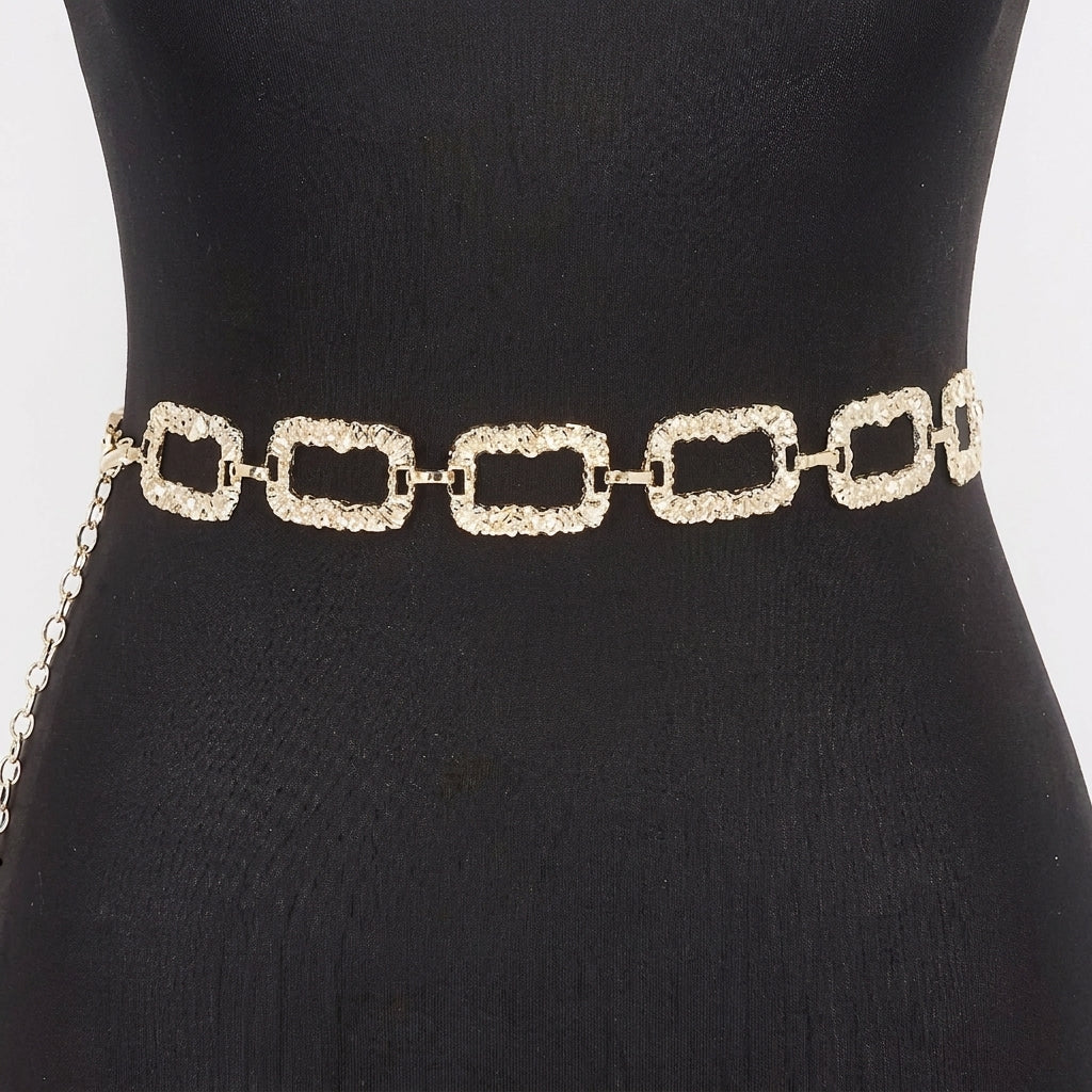 Gold chain belt with textured, rectangular links on a black mannequin.