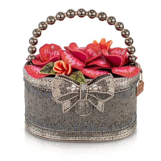 Beaded handbag with floral design and a bow, featuring a pearl handle.