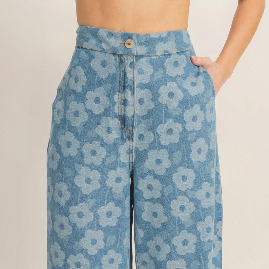 Denim pants with blue floral pattern, hand in pocket.