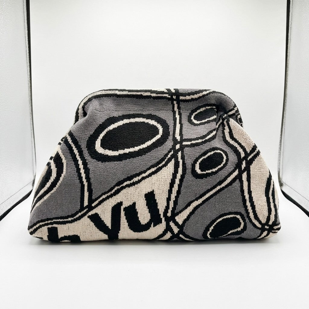 Patterned clutch with abstract black and white oval designs on display.